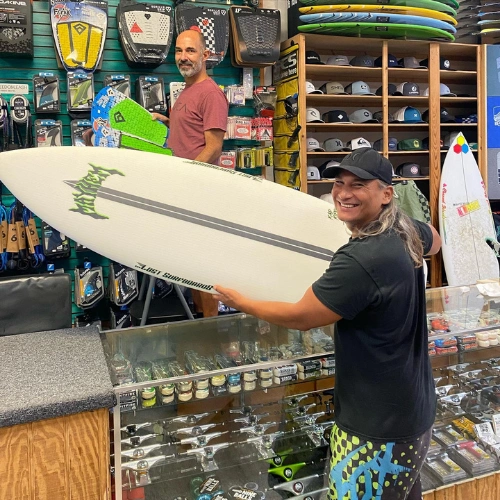 happy client buying a new surfboard